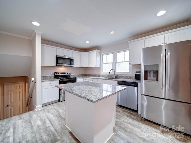 kitchen featuring white cabinetry, light wood finished floors, appliances with stainless steel finishes, and ornamental molding