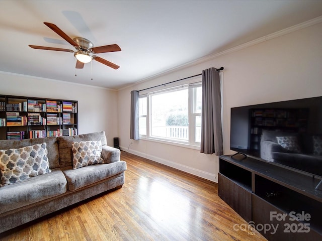 living area with ceiling fan, baseboards, wood finished floors, and ornamental molding