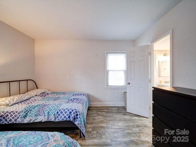 bedroom with baseboards and wood finished floors