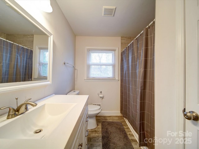 bathroom with vanity, a shower with shower curtain, toilet, and visible vents