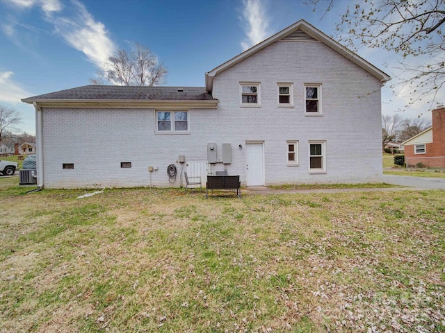 rear view of house with brick siding, crawl space, central air condition unit, and a yard