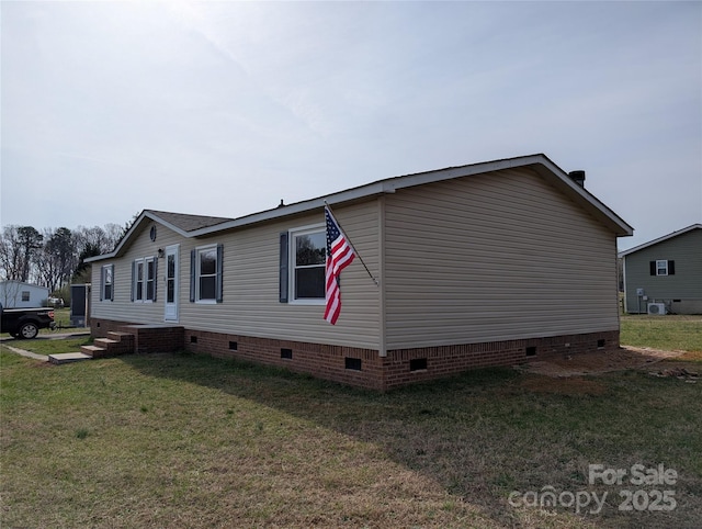 view of side of home with crawl space and a lawn