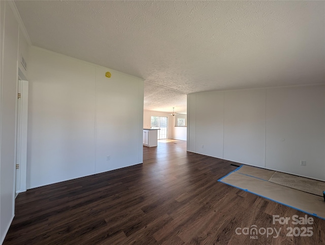 spare room with dark wood finished floors, visible vents, a textured ceiling, and an inviting chandelier