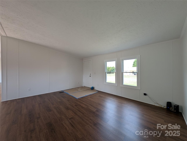 unfurnished living room with a textured ceiling and wood finished floors