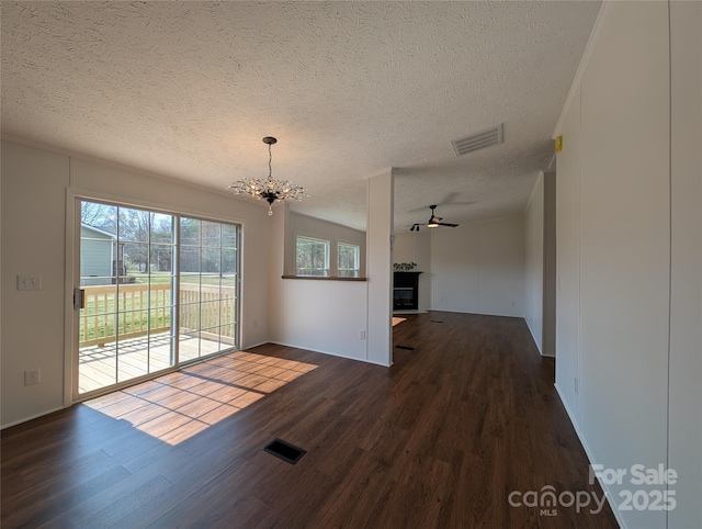 interior space featuring visible vents, ceiling fan with notable chandelier, a textured ceiling, and wood finished floors