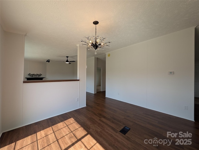 spare room with ceiling fan with notable chandelier, a textured ceiling, and wood finished floors