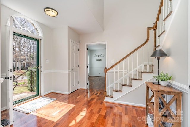 foyer with stairway, baseboards, and light wood finished floors