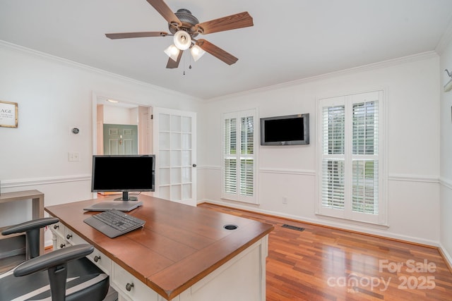 home office with a wealth of natural light, visible vents, ceiling fan, and wood finished floors