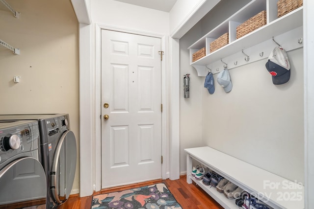 washroom with washer and dryer, laundry area, and wood finished floors