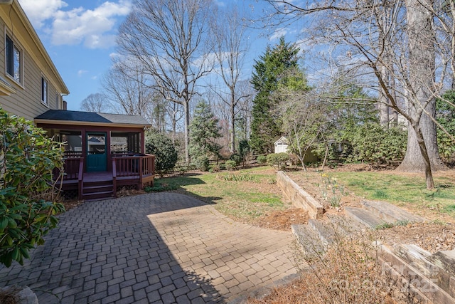 view of yard with a patio area, a wooden deck, fence, and a garden