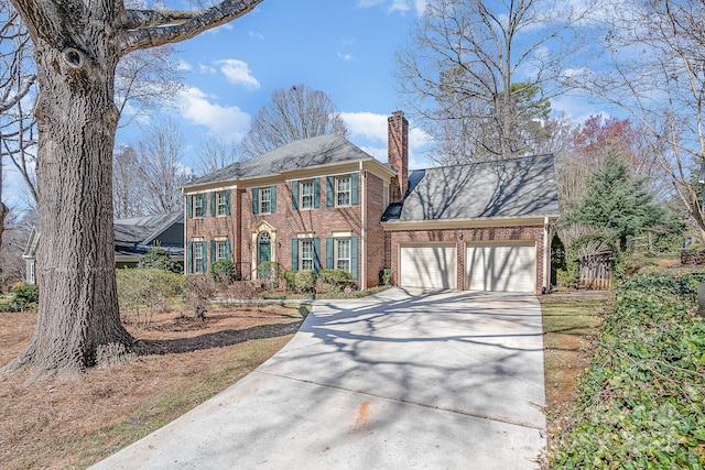 view of front facade featuring concrete driveway, an attached garage, brick siding, and a chimney