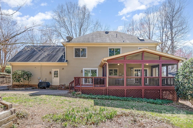 back of house with a patio area, a sunroom, and a shingled roof