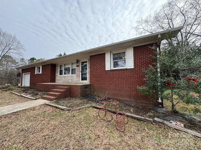 ranch-style house with crawl space, a garage, and brick siding