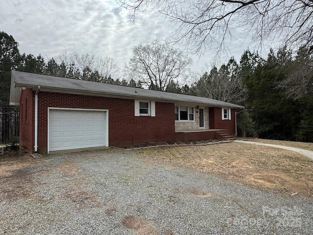 ranch-style house with a garage, brick siding, and driveway