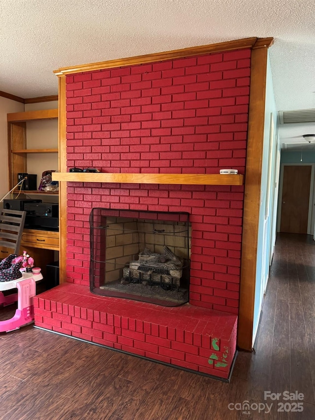 interior details with wood finished floors, a fireplace, and a textured ceiling