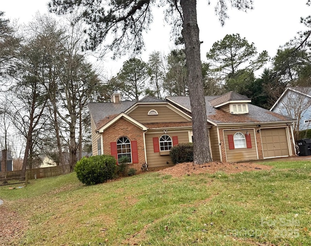 view of front facade featuring brick siding, a shingled roof, fence, a front yard, and an attached garage