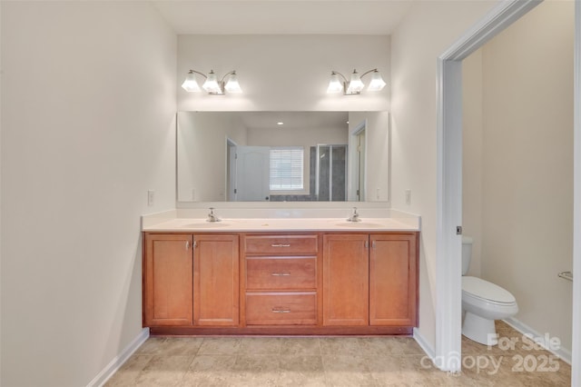 full bath with a sink, baseboards, toilet, and double vanity