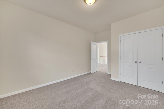 unfurnished bedroom with carpet flooring, baseboards, and a closet