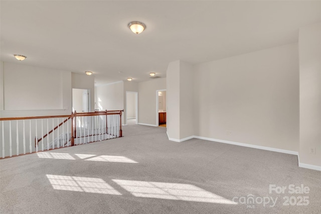 carpeted spare room featuring baseboards