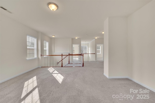 empty room with visible vents, carpet flooring, and baseboards