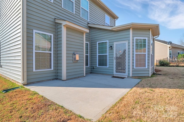 property entrance featuring a patio and a lawn