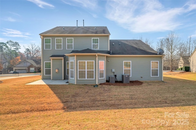 rear view of property featuring central AC unit, a patio, and a yard