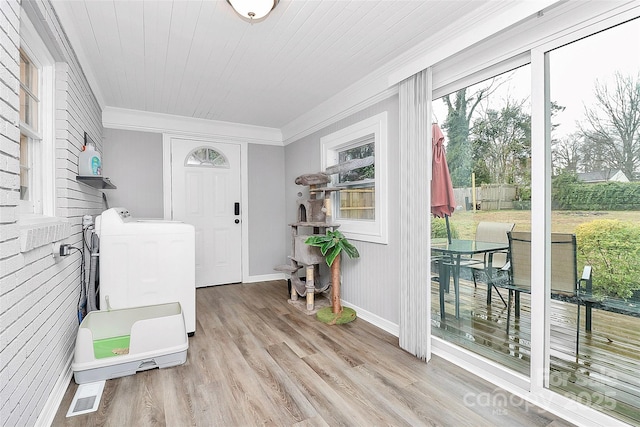 interior space featuring wood finished floors, baseboards, ornamental molding, wooden ceiling, and washing machine and dryer