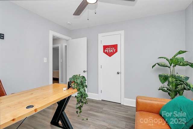 office with light wood-style floors, baseboards, and ceiling fan