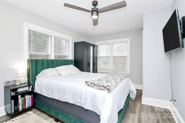 bedroom with baseboards, wood finished floors, and a ceiling fan