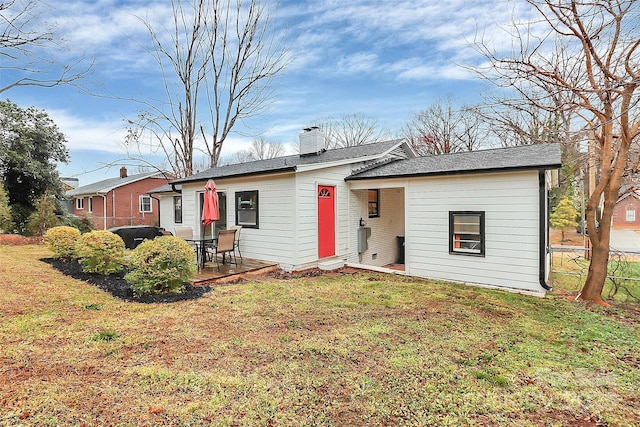 view of front of house featuring cooling unit, a front lawn, a chimney, and fence