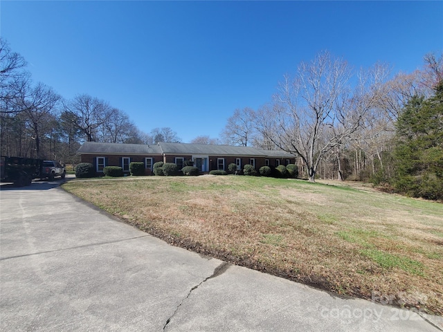 ranch-style home with a front yard and aphalt driveway