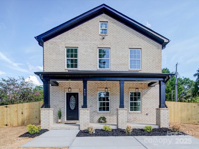 view of front facade featuring brick siding, a porch, and fence