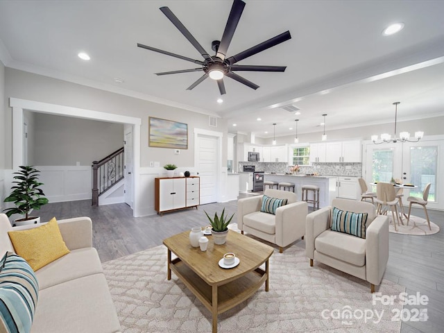 living area with recessed lighting, crown molding, stairs, and light wood-style floors