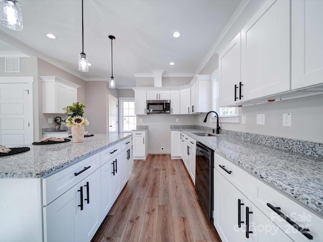 kitchen featuring visible vents, beverage cooler, a sink, stainless steel microwave, and light stone counters