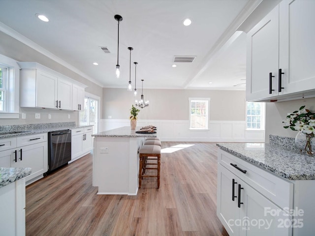 kitchen featuring visible vents, a wainscoted wall, dishwasher, light wood-style flooring, and white cabinetry