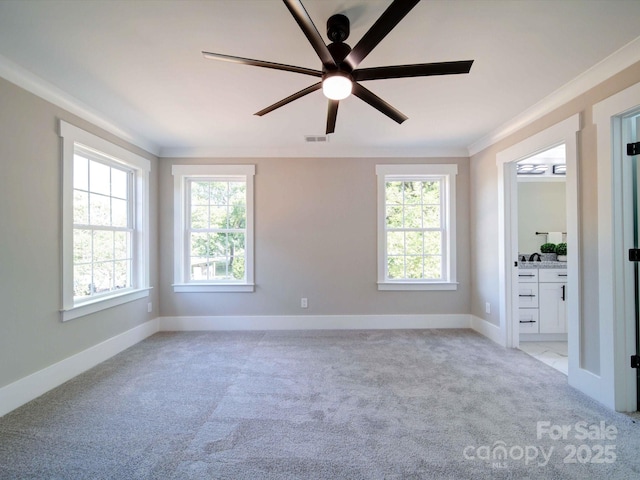 unfurnished bedroom with light carpet, ensuite bathroom, crown molding, and baseboards