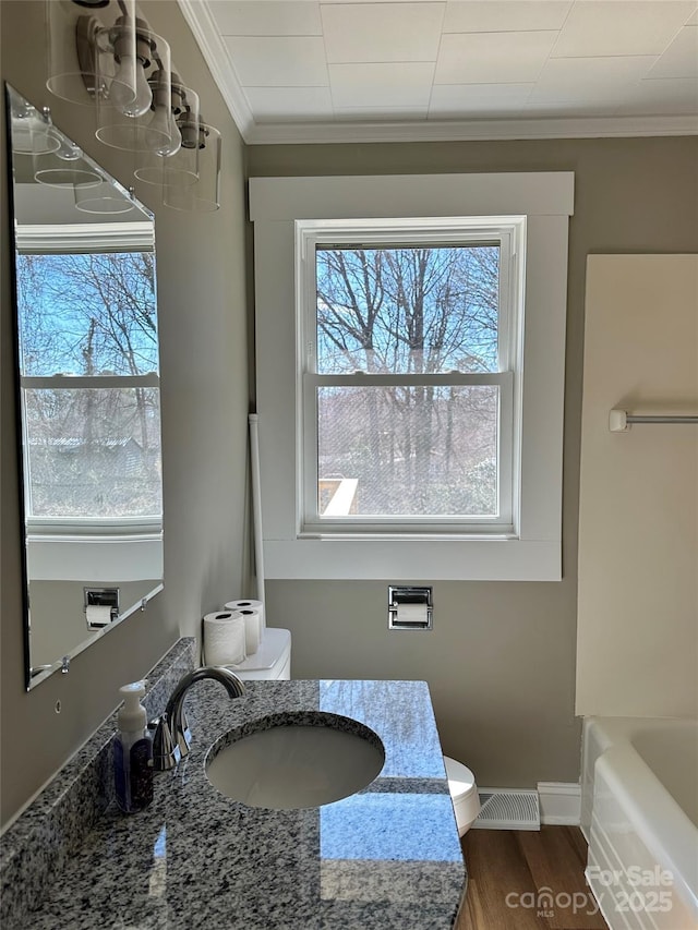 full bath with vanity, wood finished floors, visible vents, ornamental molding, and toilet