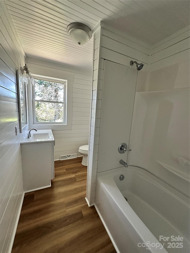 full bath with visible vents, toilet, wood finished floors, shower / bathing tub combination, and vanity