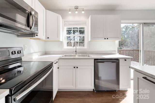 kitchen with plenty of natural light, a sink, white cabinetry, and appliances with stainless steel finishes
