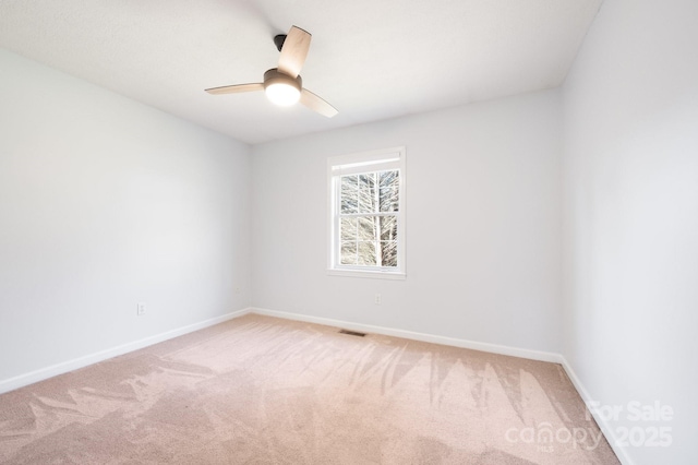 empty room featuring baseboards, visible vents, and light colored carpet