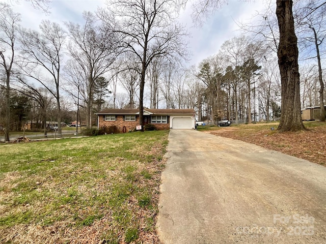 ranch-style home with brick siding, a front lawn, concrete driveway, and an attached garage