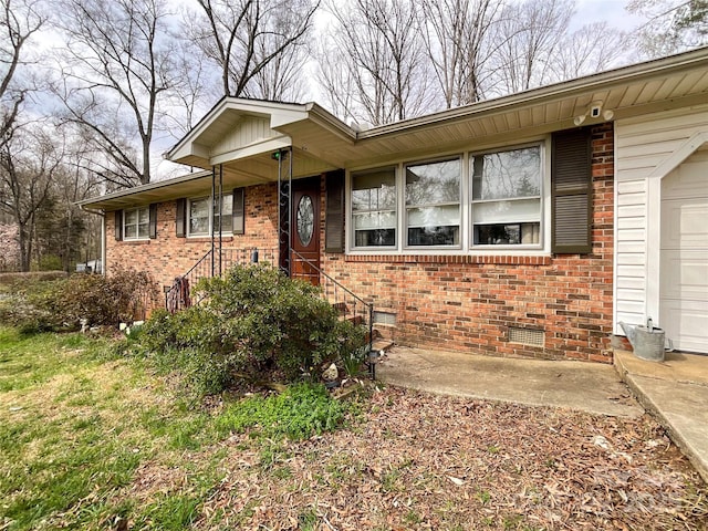 ranch-style house featuring crawl space, brick siding, and an attached garage