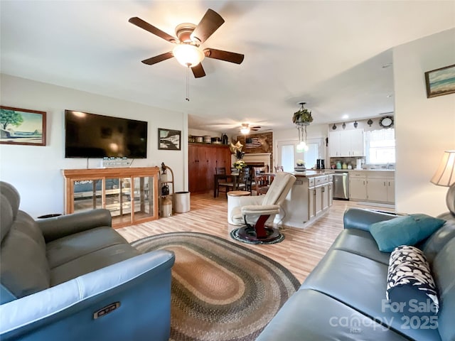 living room featuring light wood-style flooring and ceiling fan