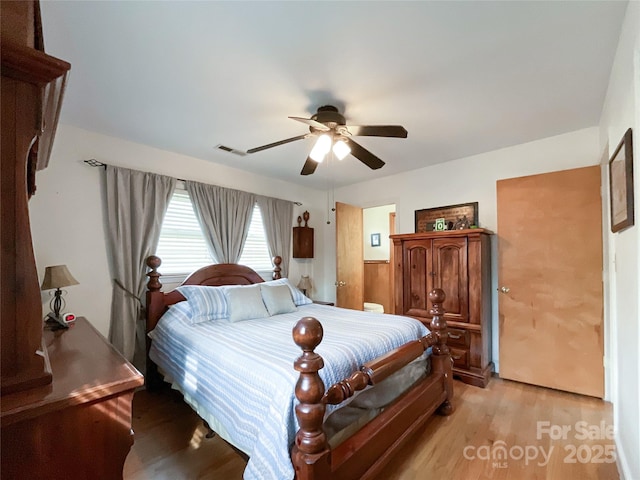 bedroom featuring visible vents, light wood-style floors, and a ceiling fan