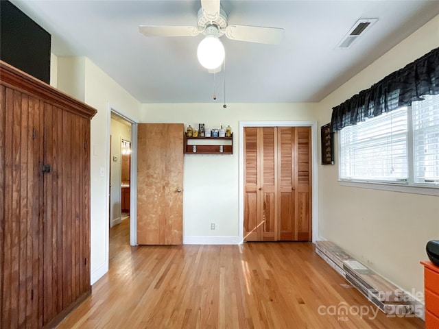 unfurnished bedroom with visible vents, a closet, light wood-style floors, baseboards, and ceiling fan