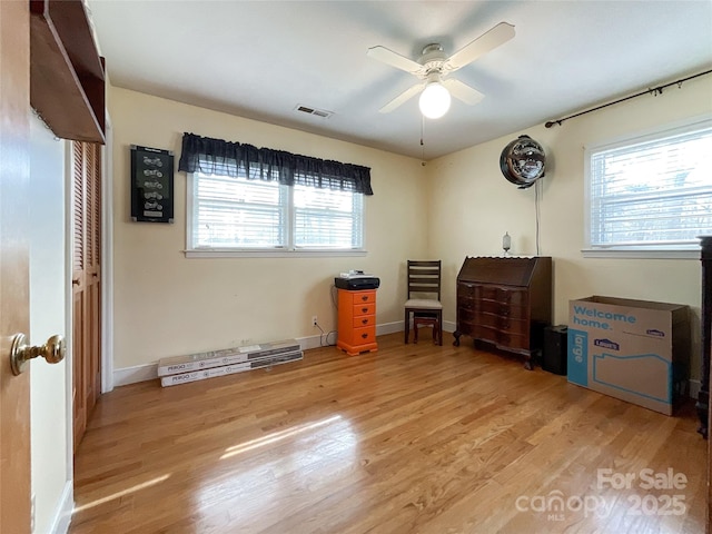 bedroom featuring baseboards, visible vents, light wood finished floors, and ceiling fan