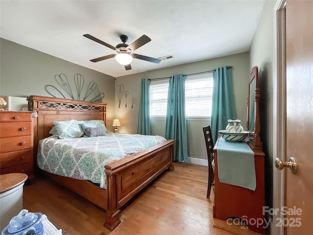 bedroom with light wood-style flooring, baseboards, visible vents, and ceiling fan