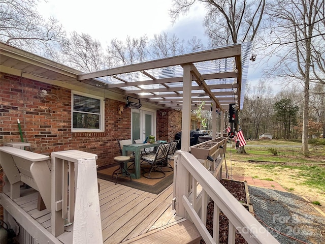 deck featuring french doors, an attached carport, area for grilling, and outdoor dining space