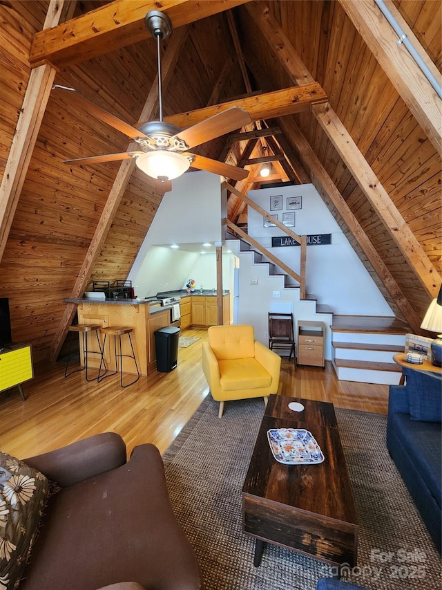 living room with light wood finished floors, vaulted ceiling with beams, and wood ceiling