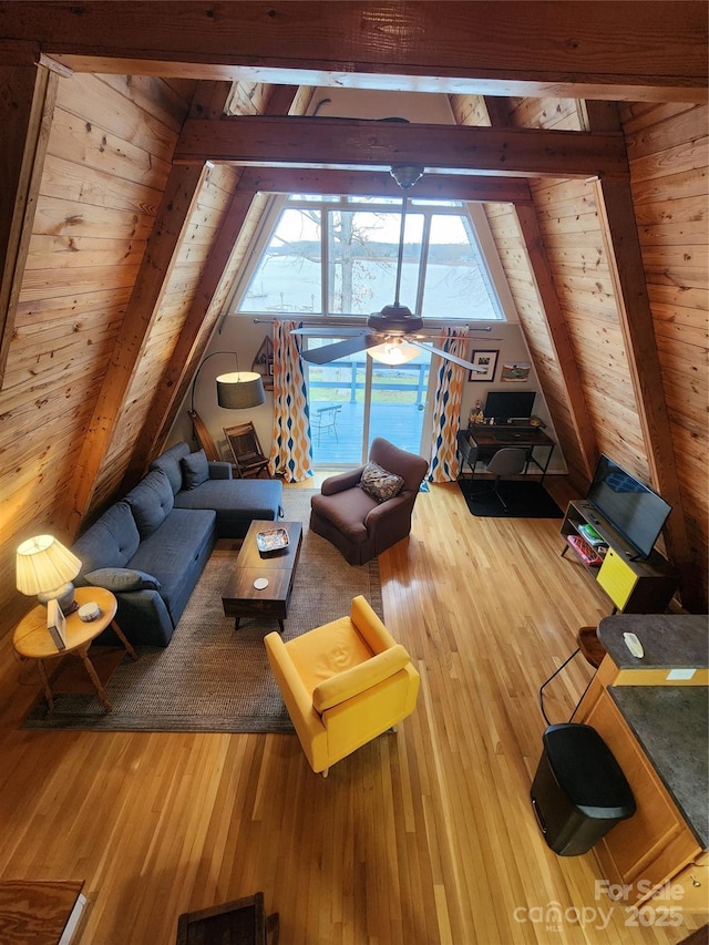 living area with wood ceiling, hardwood / wood-style floors, and vaulted ceiling with beams